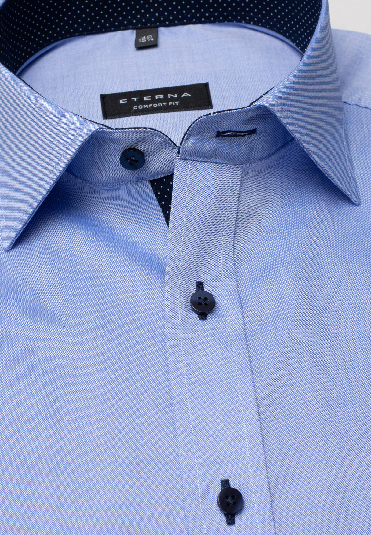 Kent-Kragen eines Eterna Business-Hemdes in der Farbe mittelblau. Patchungen, Knöpfe und Knopflöcher in Farbe dunkelblau.